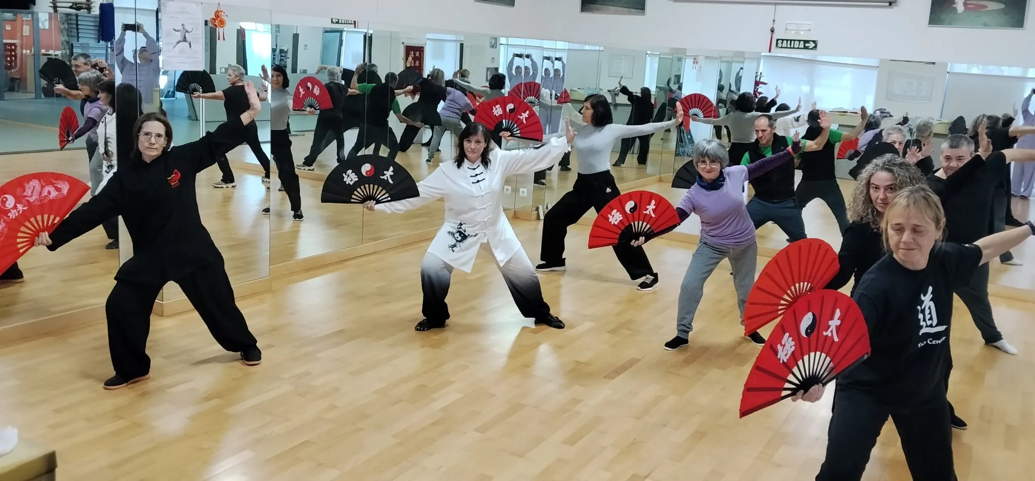 Clase grupal de Tai Chi con abanicos