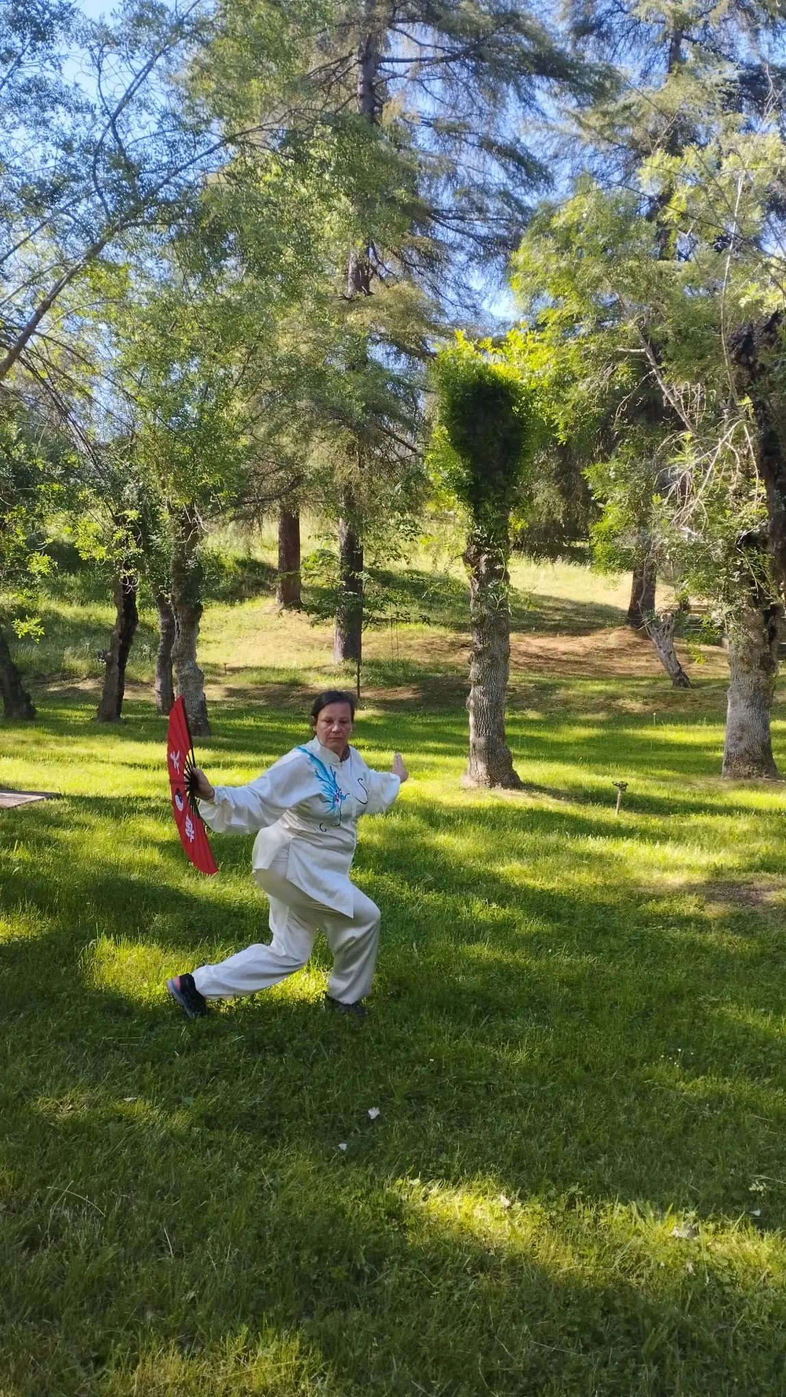 Maite García practicando Tai Chi con abanico rojo exterior