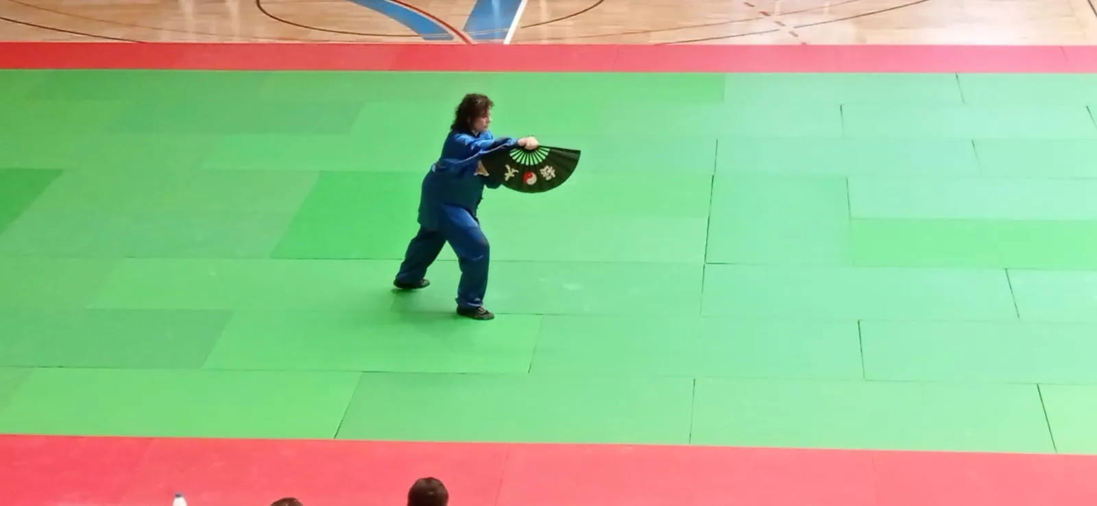 Maite García en competición de wushu con abanico negro